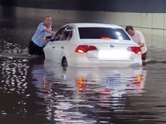 洛阳大雨致司机被困 交警挽起裤子帮忙推车